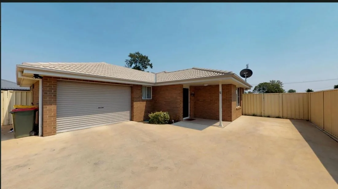 Exterior of one of our Yes WeCare Services SIL homes, a modern single-storey brick house with a driveway and secure fencing.